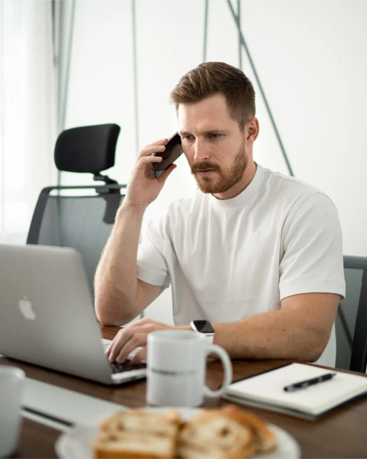Business owner taking a call while working on his laptop