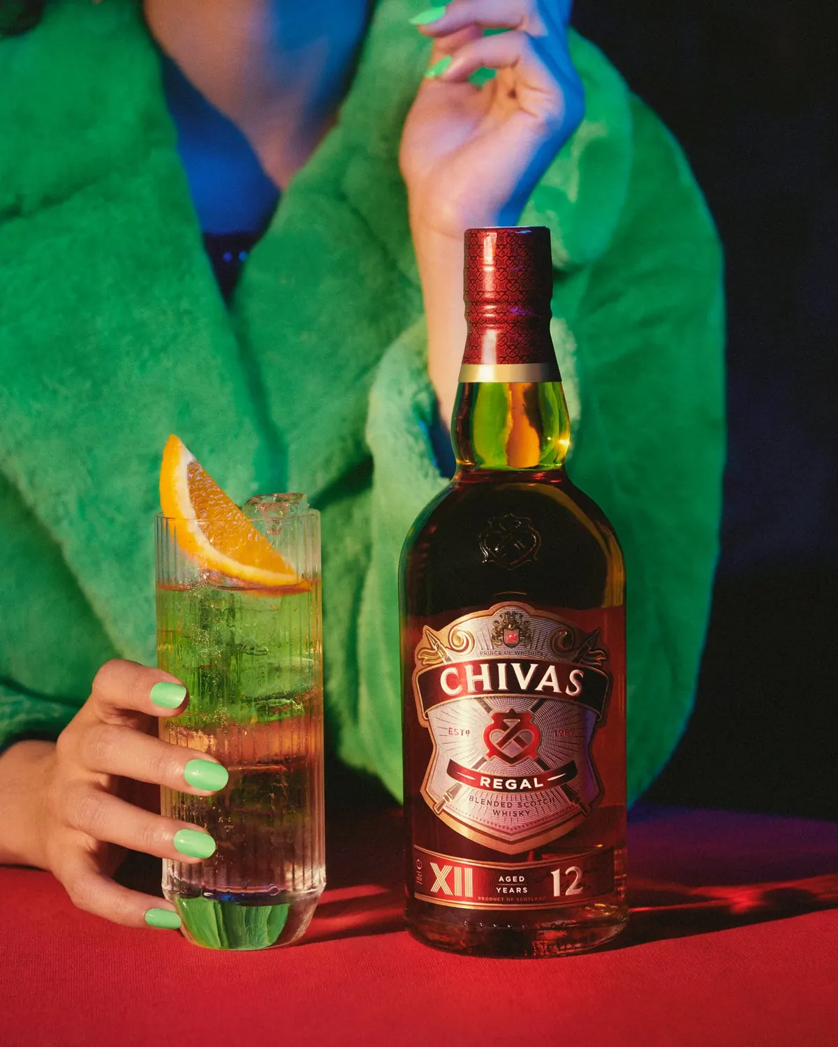 Chivas Regal whisky bottle beside a citrus highball