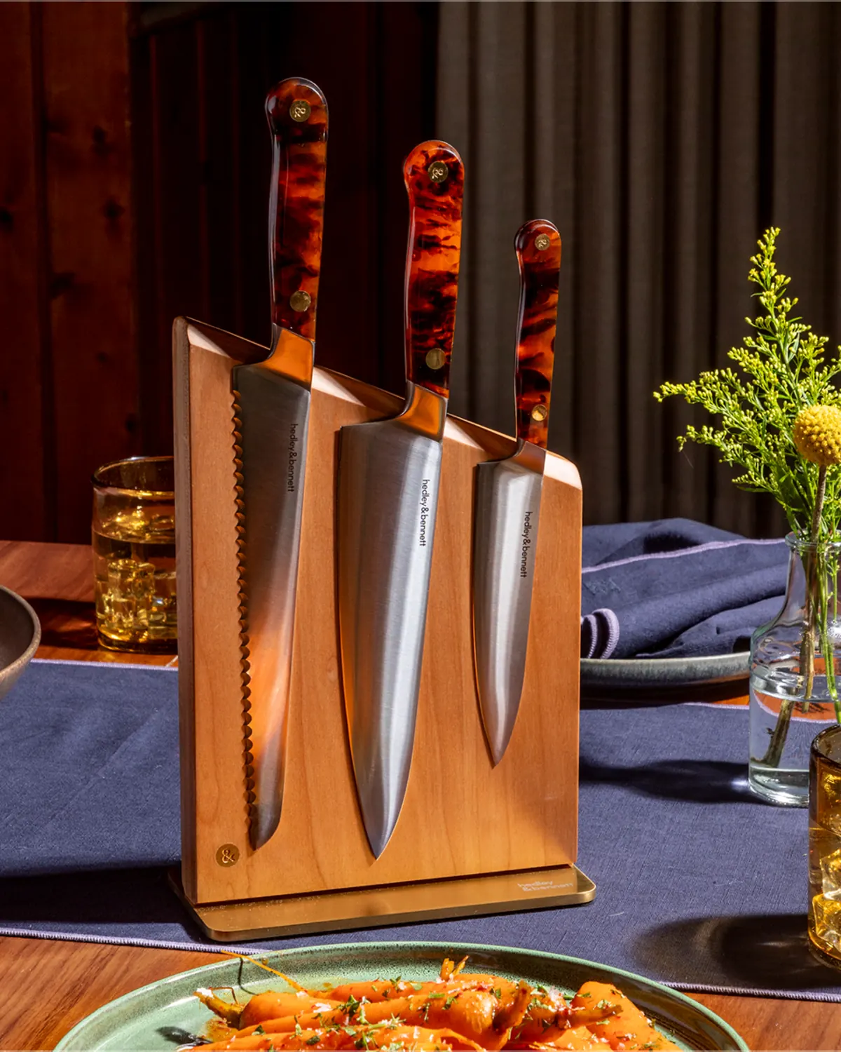 Kitchen knives displayed in a wooden block beside plated food