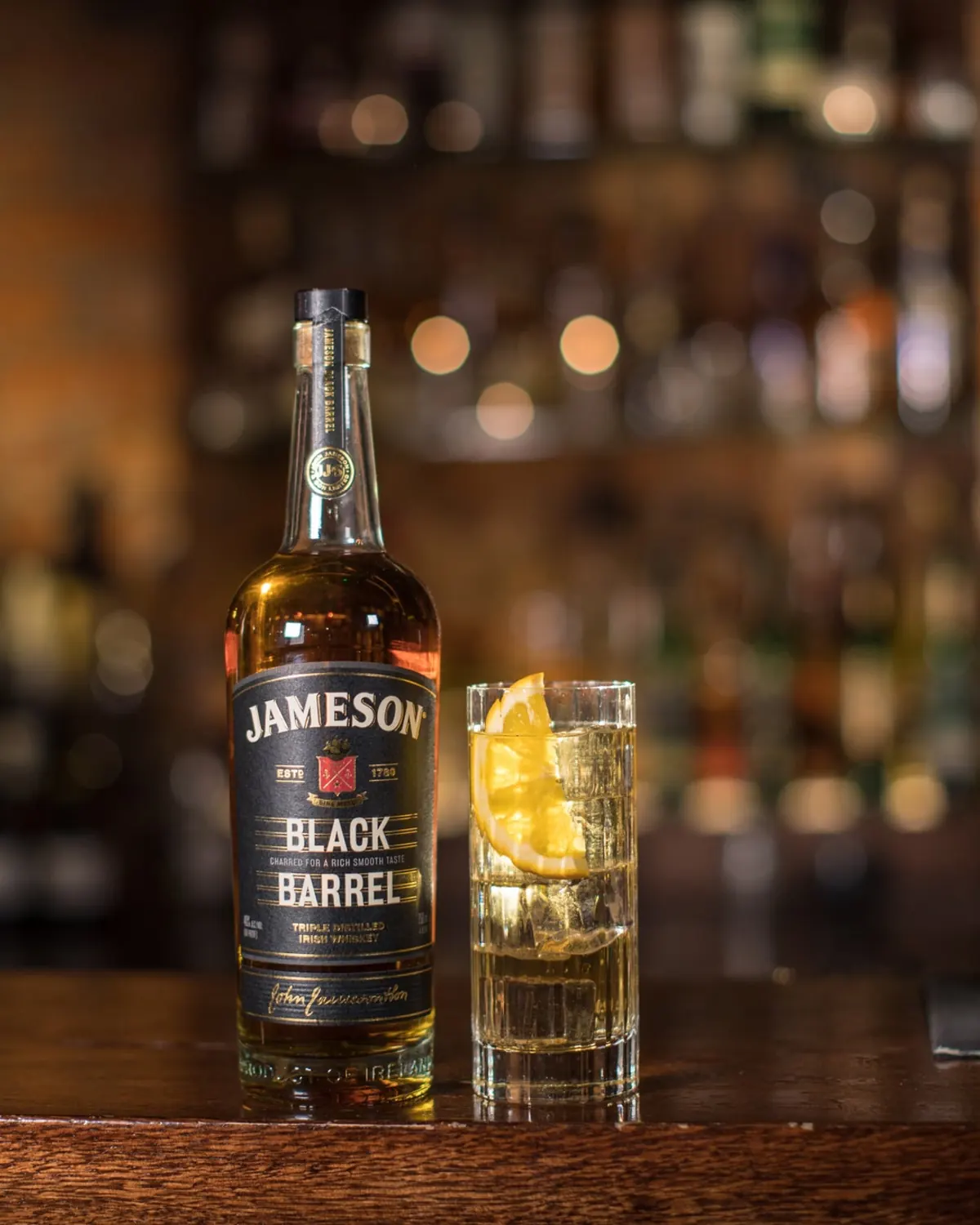 Jameson Black Barrel whiskey bottle beside a citrus highball