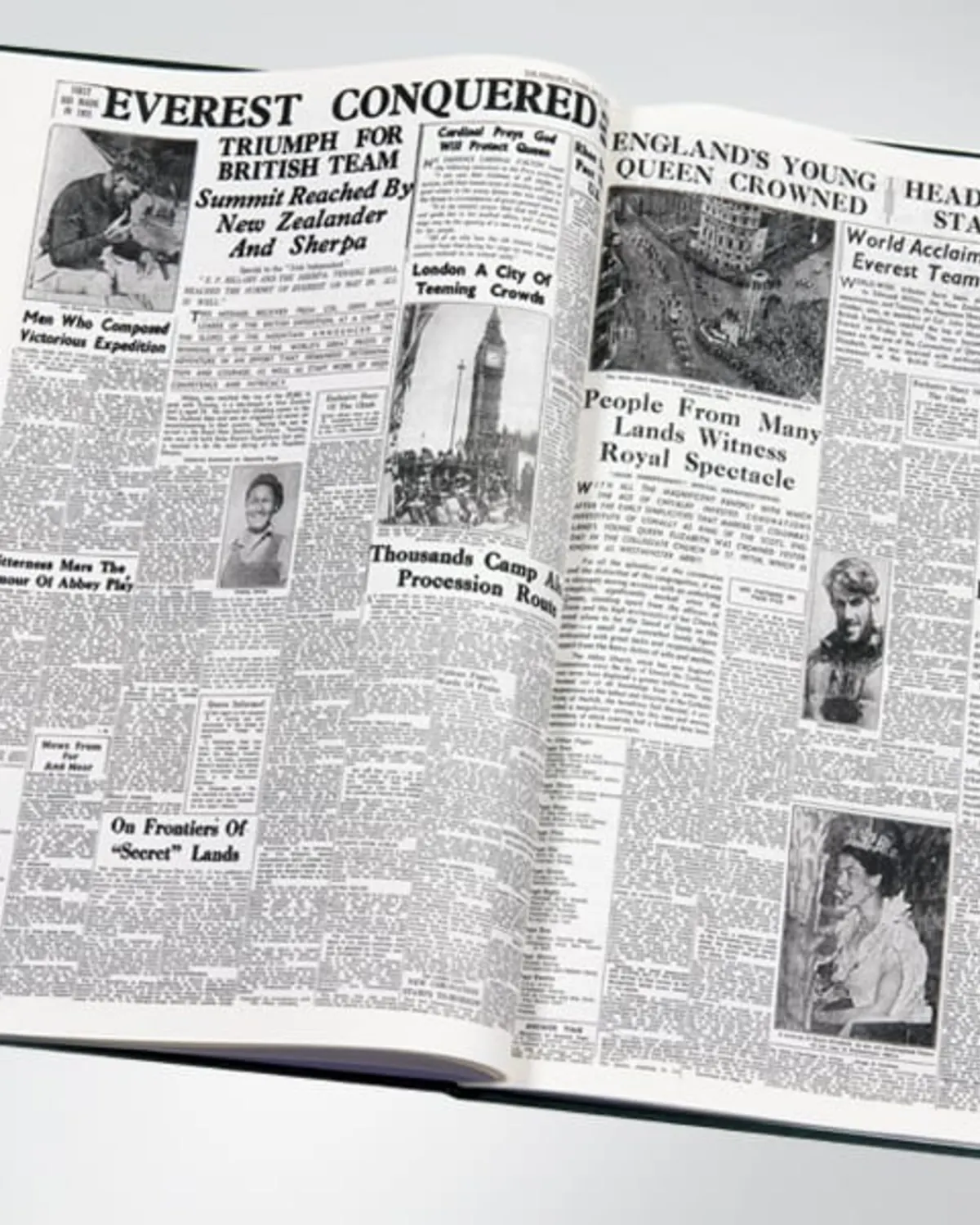 Open commemorative book reproducing historic newspaper front pages