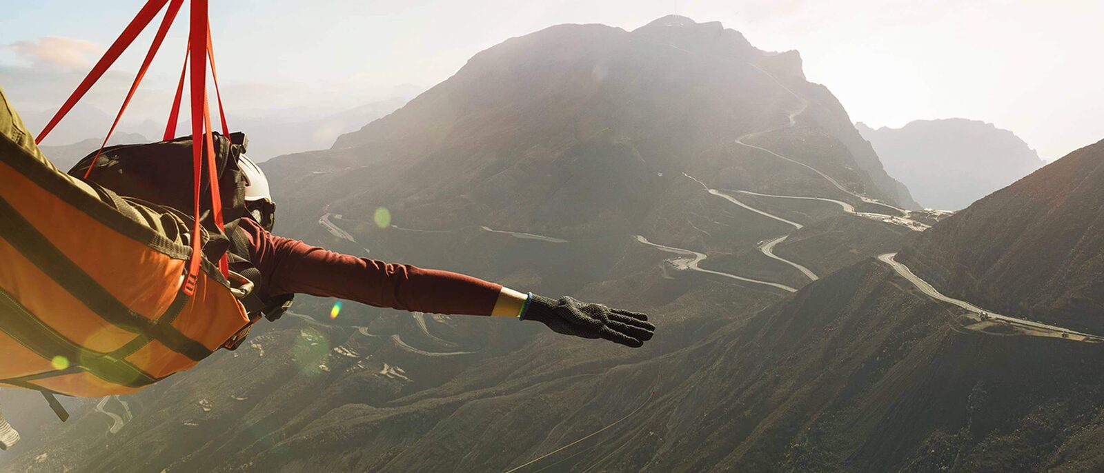 A zipline rider above mountain roads in Ras Al Khaimah